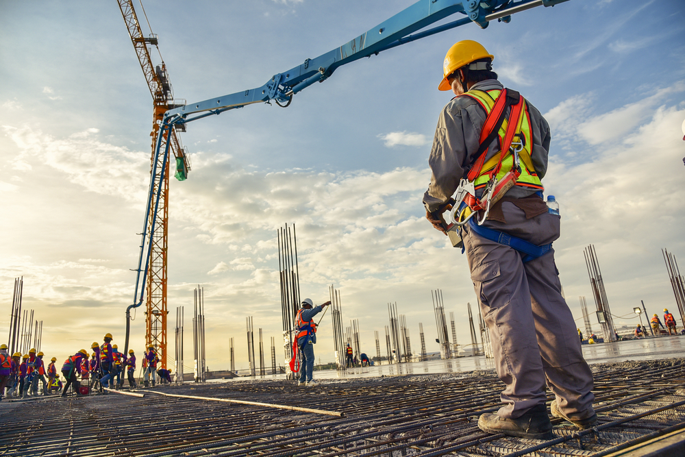 construction worker looking up at a crane