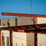 construction workers moving a beam into place