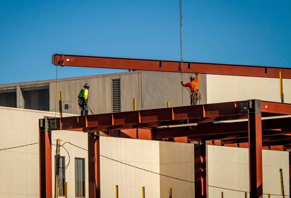 construction workers moving a beam into place